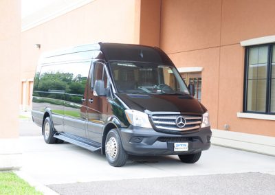 A black funeral limousine parked in front of a building