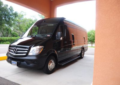 A black funeral limousine parked in front of a building